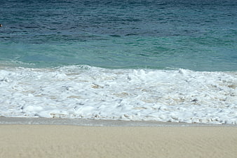 Foamy Ocean Waves Washing Up on Sandy Beach Shore