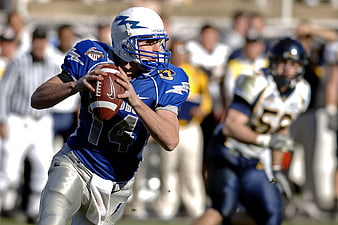 American Football Quarterback in Blue Uniform Preparing to Throw