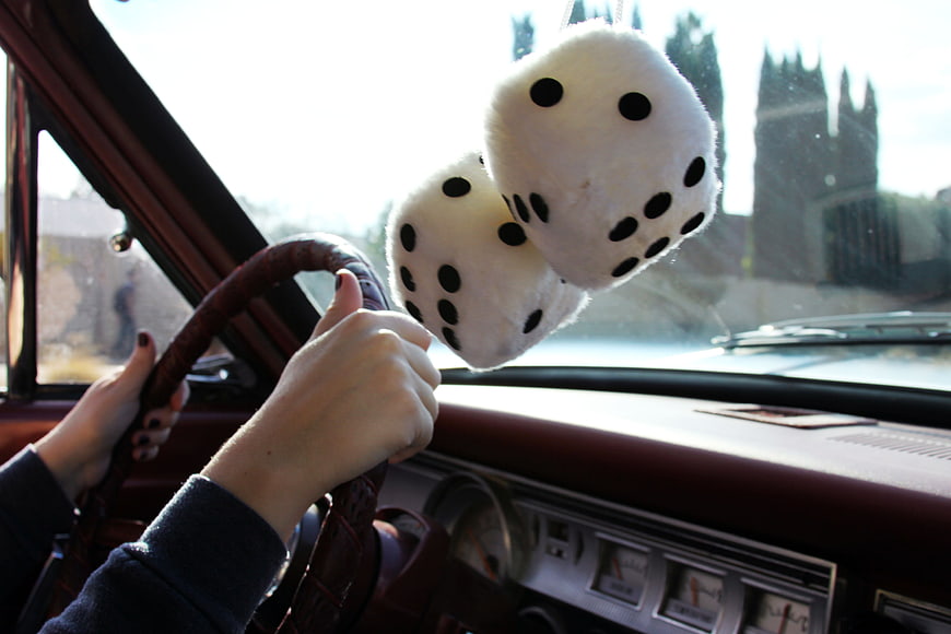 Vintage car interior with fuzzy dice hanging from rearview mirror