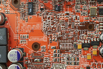 Close-up of orange electronic circuit board with microchips