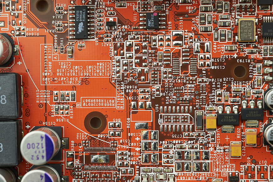 Close-up of orange electronic circuit board with microchips