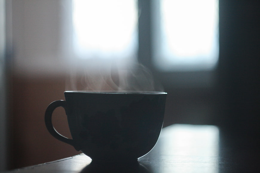 Silhouette of Steaming Coffee Cup on Table