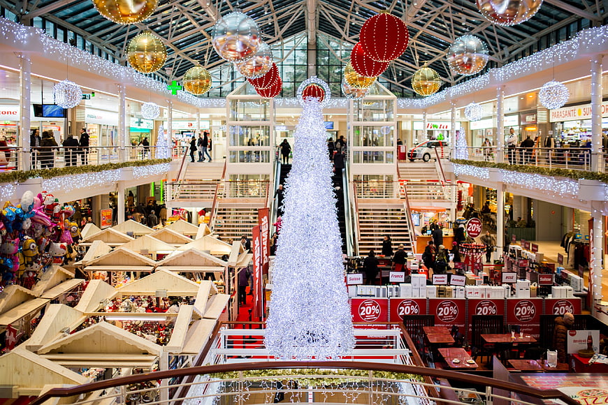 Festive Shopping Mall Interior with Christmas Tree and Market Stalls