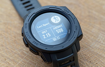 Close-up of black GPS hiking smartwatch on wooden surface