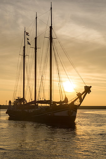 Silhouette of Three-Masted Sailboat at Golden Sunset