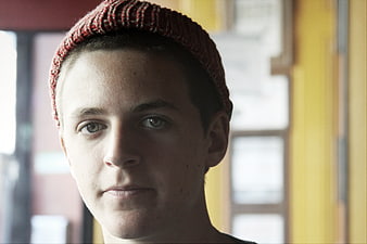 Portrait of young man in red beanie looking at camera