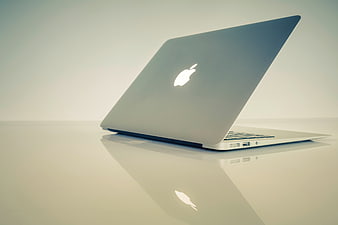 Silver Apple MacBook Laptop on Reflective White Surface