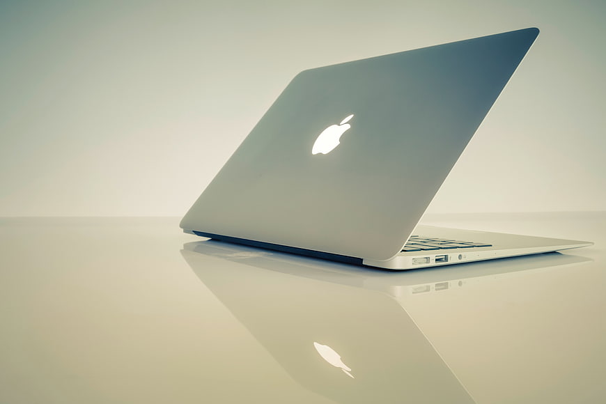 Silver Apple MacBook Laptop on Reflective White Surface