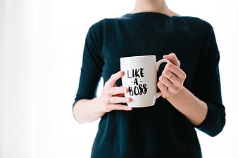 Woman holding white mug with like a boss text