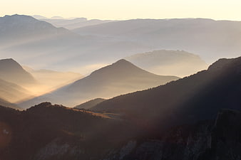 Misty Mountain Landscape at Sunrise with Sunbeams