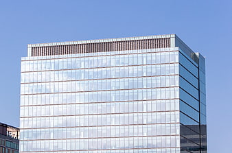 Modern glass office building against blue sky