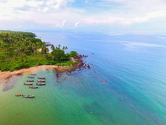 Aerial View of Tropical Beach with Longtail Boats and Palm Trees
