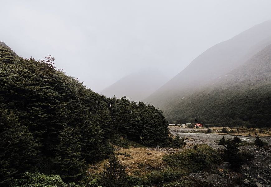 Misty mountain valley with river and distant houses