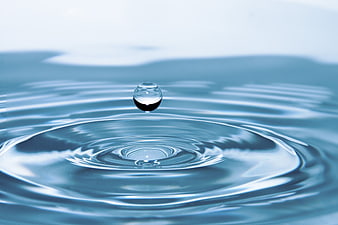 Water Drop Splash with Ripples on Blue Surface