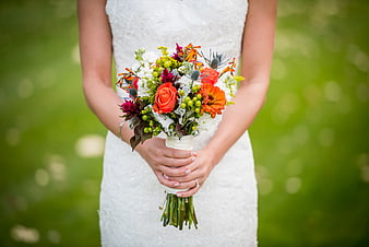 Bride holding colorful wedding bouquet outdoors