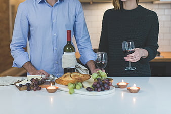 Couple enjoying wine and cheese in a cozy kitchen
