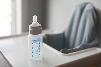Empty baby bottle on white high chair tray