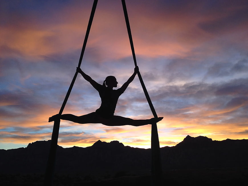 Silhouette of Woman Doing Aerial Yoga at Sunset