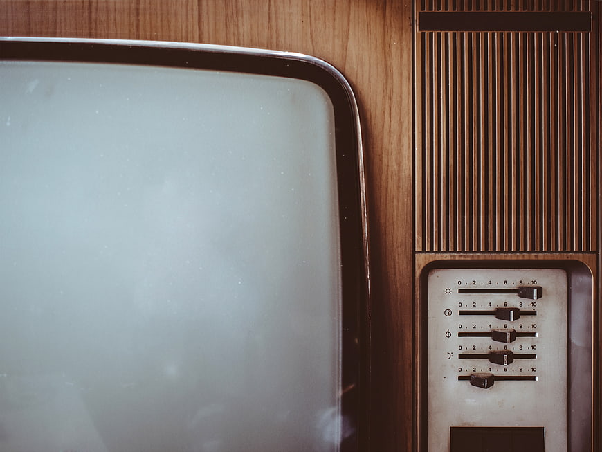 Close-up of vintage television with wooden casing and control knobs