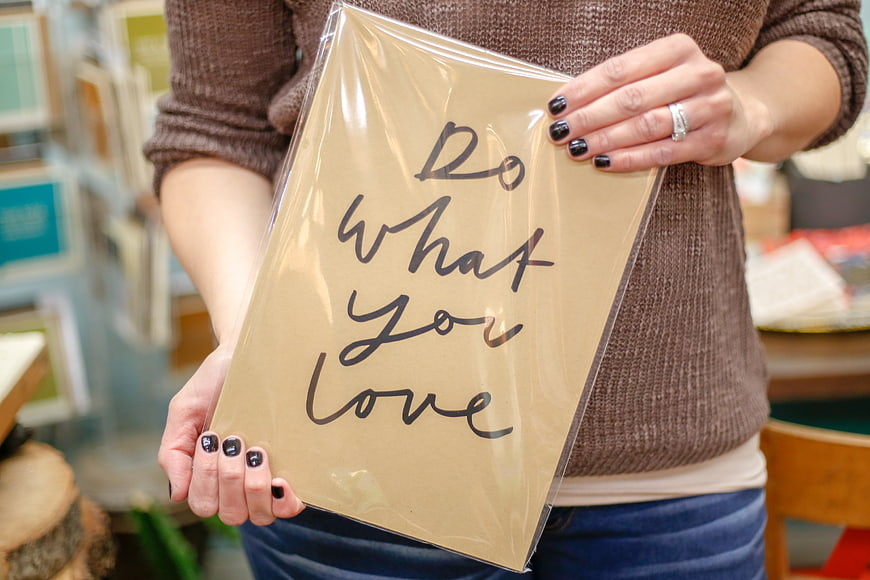 Woman holding inspirational 'Do what you love' print