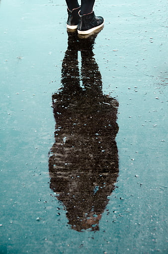 Woman's reflection in icy blue water