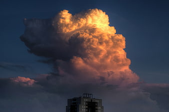 Dramatic golden sunset cloud over city building silhouette