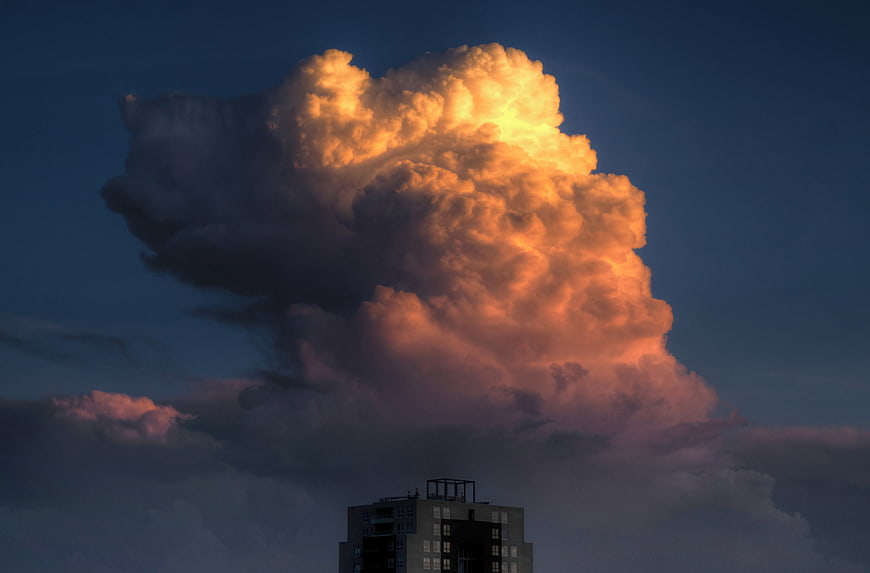 Dramatic golden sunset cloud over city building silhouette