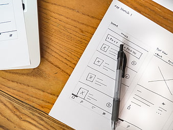 Hand-drawn app wireframe sketch on paper with pen