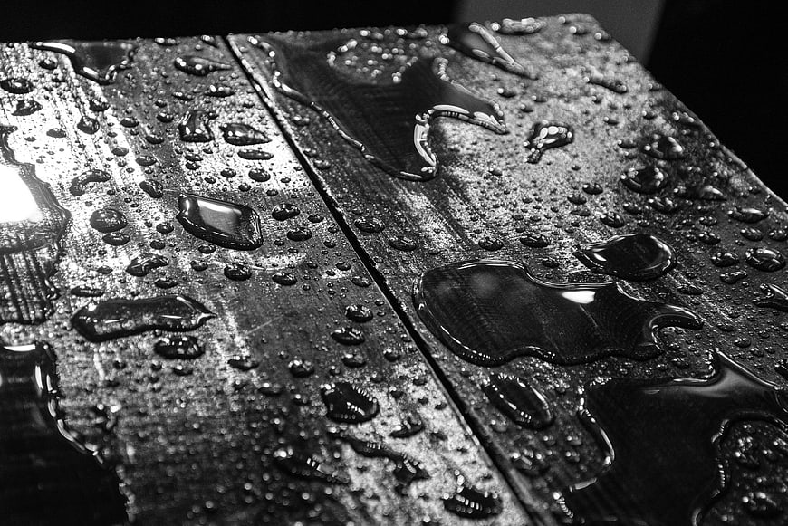 Black and white macro of water droplets on wet wood