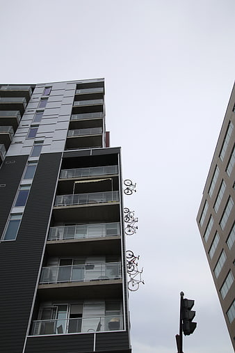 Low angle view of modern apartment building with hanging bicycles