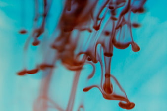 Abstract red ink swirling in blue water background