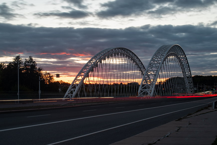 Long Exposure Traffic Light Trails on Modern Arch Bridge at Sunset