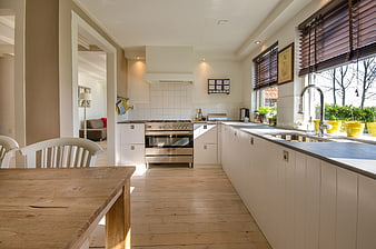 Modern white kitchen with wooden table and natural light