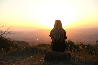 Woman Watching Sunset Over Hazy Mountain Valley