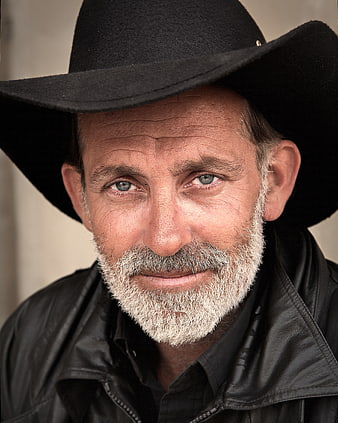 Portrait of mature cowboy with beard and black hat