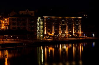 Night View of Illuminated Riverside Restaurant with Water Reflections