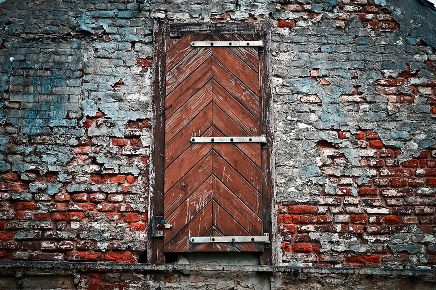 Weathered Brick Wall with Closed Wooden Shutters