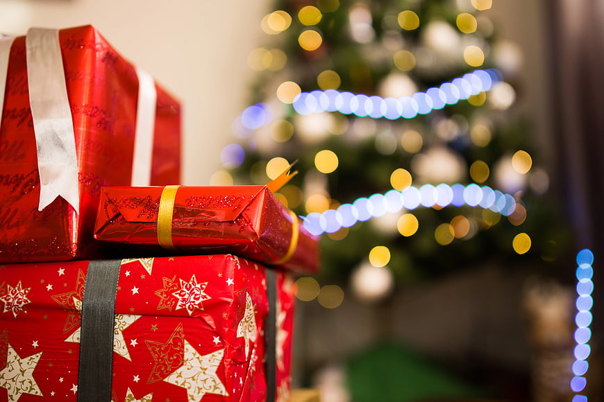 Red Christmas Gifts Under Blurred Tree