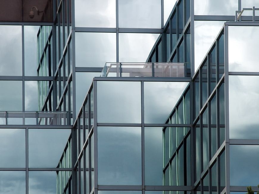 Modern Glass Office Building Architecture with Cloud Reflections