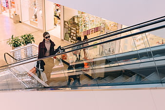 Fashionable Woman Shopping on Escalator in Modern Mall