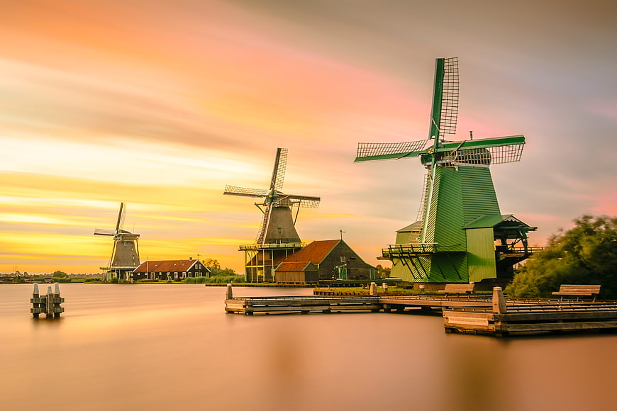 Traditional Dutch Windmills at Sunset Over Calm Water
