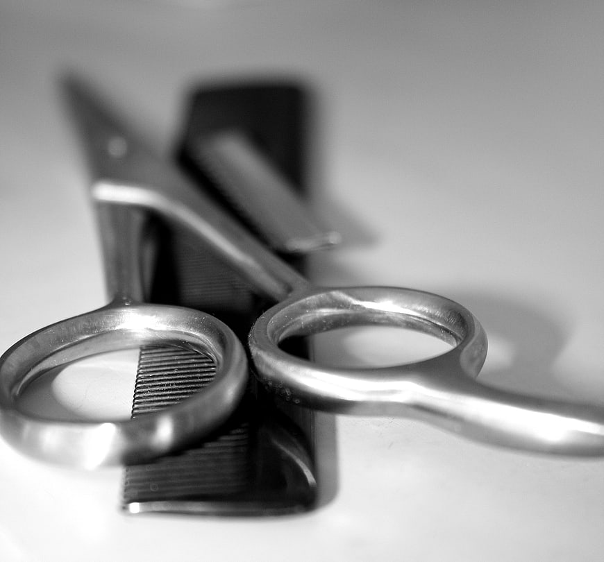 Black and white barber scissors and comb on white background