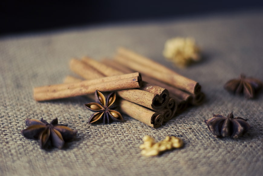 Cinnamon sticks and star anise on rustic burlap background