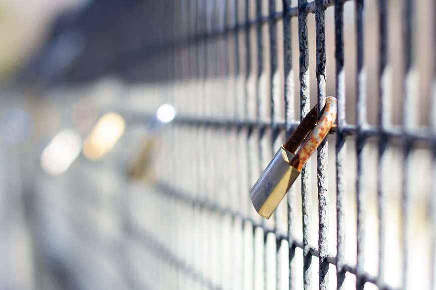 Rusty Padlock on Metal Fence Close Up