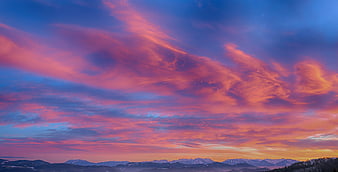 Vibrant Pink and Purple Sunset Sky Over Snowy Mountain Range