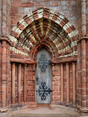 Ornate Romanesque Stone Archway with Wooden Door