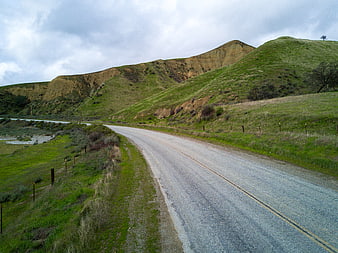 Winding Country Road Through Green Hills and Cliffs