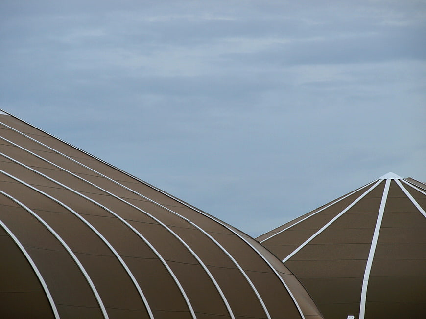 Modern brown dome architecture with white geometric lines against sky