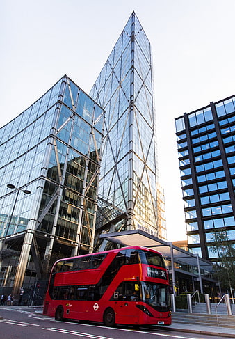 Red double-decker bus in front of modern glass skyscrapers