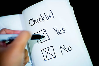 Hand Checking Yes Box on Handwritten Checklist